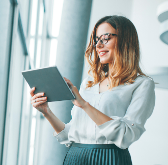 Young woman standing in front of a window using a tablet